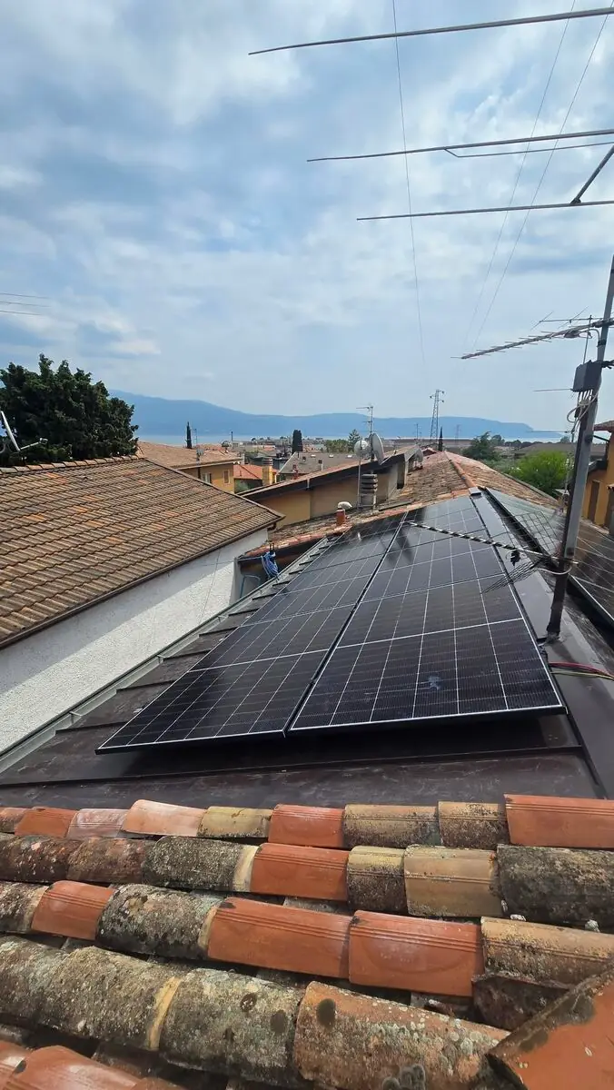 Impianto fotovoltaico GV LUX su un tetto in tegole, con panorama del lago